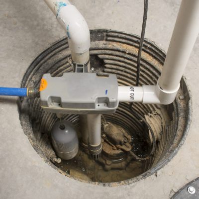 A sump pump installed in a basement of a home with a water powered backup system.